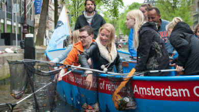 I turisti in barca pescano i rifiuti dal canale: accade ad Amsterdam