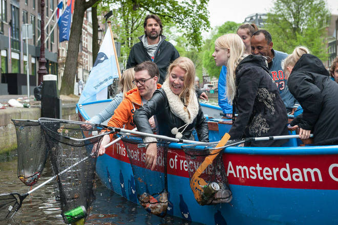 I turisti in barca pescano i rifiuti dal canale: accade ad Amsterdam