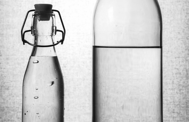 Bottiglia d’acqua di vetro pulita con l'aspirina