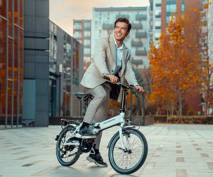 Un ragazzo sorridente e vestito bene che va in bici